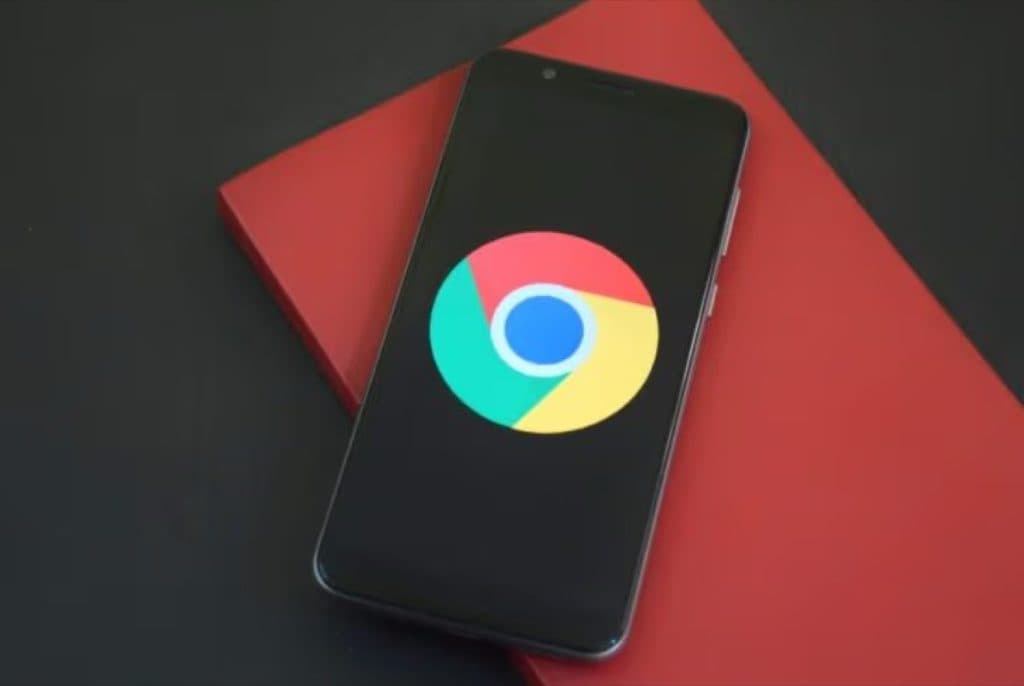 Smartphone showing the Chrome browser logo on a red notebook